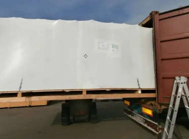 Produktionslinie sicher in Schrumpffolie verpackt und für den Export im Container verladen